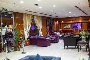 a lobby with purple couches and televisions at Quiet Rooms 1 Serviced Apartments in Riyadh