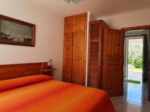 sypialnia z łóżkiem z pomarańczową narzutą w obiekcie Appartamenti Luongo w mieście Ischia