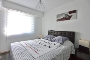 Un dormitorio con una cama con un cartel. en Le Cannois, en Le Cannet