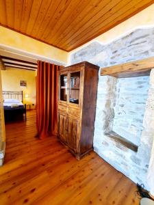 a room with a stone wall and a wooden floor at Hellen Apartment in Verbania