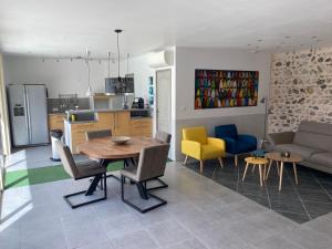 a kitchen and living room with a table and chairs at Gîtes du Bonheur in Ausson