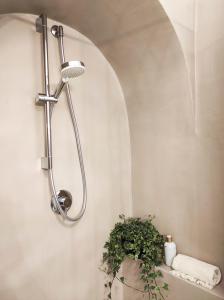 La salle de bains est pourvue d'une douche et d'un lavabo avec une plante. dans l'établissement CALMAPIANTA home for green lovers, à Putignano