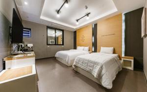 a hotel room with two beds and a television at Motel Rings in Gunsan