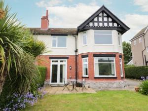 a detached house with a patio and garden at The Anchorage in Colwyn Bay