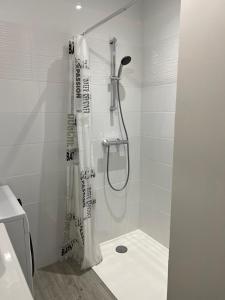 a bathroom with a shower with a shower curtain at le Rocher in La Plaine-sur-Mer