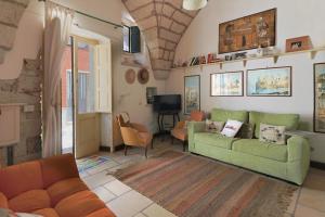 een woonkamer met een groene bank en een tafel bij Casa vacanza Soletina a Soleto cuore del Salento in Soleto