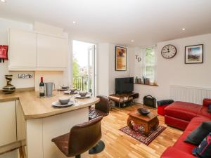 una cucina e un soggiorno con divano rosso di Apartment 4 10 Somers Court a Paignton