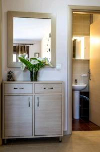 a bathroom with a dresser with a mirror and a sink at Canal Luxury Apartments in Nea Potidaea +37 photos