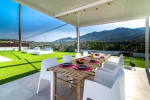 a table and chairs on a patio with a view at PALM TREE VILLA - 5BDR Paradise Pool / Chill Out Beds in Torremolinos