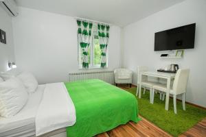 a bedroom with a bed and a table and a television at Eva Luxury Rooms & Apartments in Plitvička Jezera
