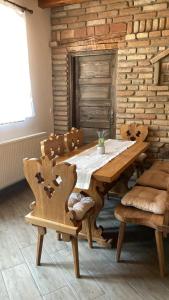 ein Esszimmer mit einem Holztisch und Stühlen in der Unterkunft Kisdió Vendégház in Dég