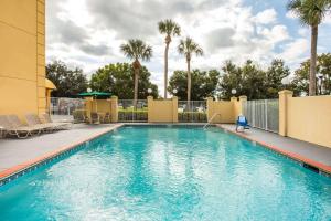 a swimming pool at a resort with palm trees at La Quinta by Wyndham Melbourne Viera in Melbourne +32 photos
