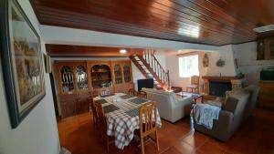 ein Wohnzimmer mit einem Tisch und ein Wohnzimmer mit einer Treppe in der Unterkunft Casa da Magnólia in Raposeira