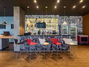 a room with a bar with chairs and a wall covered in graffiti at ibis Guaiba in Guaíba