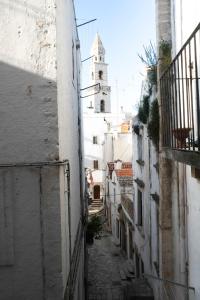 an alley way with a tower in the distance at CALMAPIANTA home for green lovers in Putignano