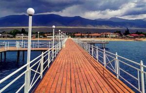 a wooden dock with a white railing on the water at Коттедж в ЦО Париж in Chok-Tal