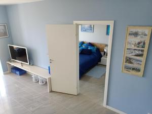 a room with a bedroom with a bed and a mirror at BLUE MORNING - nowoczesny apartament z widokiem na morze PLAYA BALTIS in Międzyzdroje