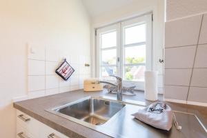 eine Küche mit Spüle und Fenster in der Unterkunft Haderslebener Str 28 in Westerland + 36 Fotos