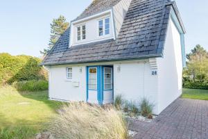 ein kleines weißes Haus mit blauer Tür in der Unterkunft Haderslebener Str 28 in Westerland