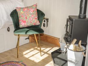 a green chair with a pillow on it next to a stove at Ewes Welcome in Cottingham