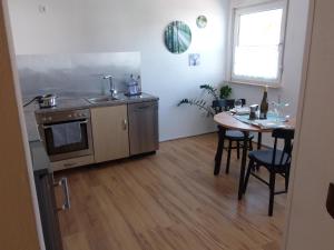 a kitchen with a table and a sink and a stove at Ferienwohnung Palatina Annweiler in Annweiler am Trifels