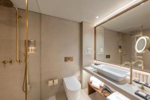 a bathroom with a bath tub, toilet and sink at Grand Hotel Açores Atlântico in Ponta Delgada