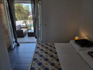- une chambre avec un lit et une vue sur un balcon dans l'établissement Villa FLAMINGO Deluxe Novalja, à Novalja