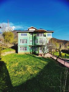 a large house with a large lawn in front of it at Calm Holiday Inn in Srinagar