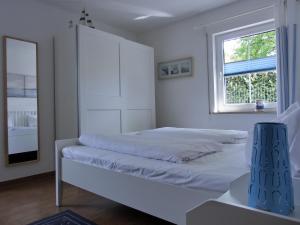 - une chambre blanche avec un lit et une fenêtre dans l'établissement Ferienwohnung G11 "Idyll", à Graal-Müritz
