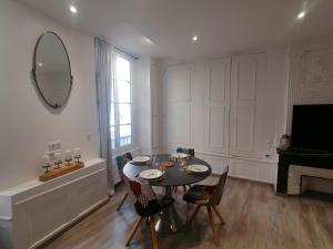 - une salle à manger avec une table, des chaises et un miroir dans l'établissement Appartement F2 dans le centre historique, au Puy-en-Velay