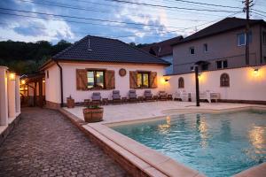 a house with a swimming pool in front of a house at Complex Butoaiele Transilvaniei - Cazare & SPA - Natura - Restaurant in Mediaş