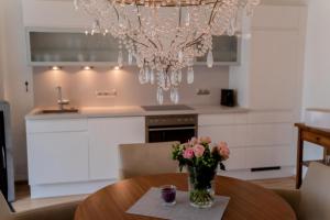a vase of flowers on a table under a chandelier at Apartment Bungalow Sekirn in Sekirn