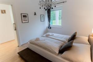 a large bed in a room with a chandelier at Apartment Bungalow Sekirn in Sekirn
