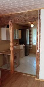 a kitchen with a table and a refrigerator at Sodyba Prie Beržoro Ežero in Plateliai