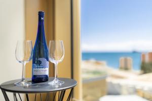 una botella de vino sentada en una mesa con dos copas en INTEMPO SKY RESORT by Costa Activa Rentals, en Benidorm