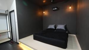 a bedroom with a black bed with two pillows at Hotel Cineplex in Coimbatore