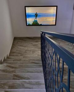 a television on a wall next to a staircase at Q-Panzió in Tata