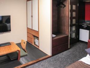una sala de estar con escritorio y una habitación con chimenea en HOTEL LiVEMAX Kyoto Ekimae en Kioto