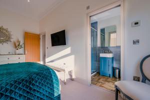 Un dormitorio con una cama azul y un espejo. en Derwent House Apartments, en Scarborough 122 fotos más
