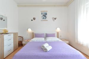 ein Schlafzimmer mit einem lila Bett mit Handtüchern darauf in der Unterkunft Apartment Silvio 1779 in Banjole