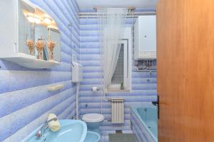 ein blaues Badezimmer mit Toilette und Waschbecken in der Unterkunft Apartment Silvio 1779 in Banjole