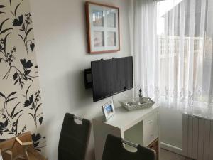 a room with a desk with a tv and two chairs at Ferienwohnung Buhne 33 in Hooksiel