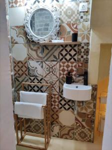 a bathroom with a sink and a mirror at Zaira's Apartment Corfu Town in Agios Rokkos