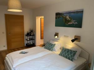 a bedroom with a bed with white sheets and green pillows at Carlotta Apartment in Reifnitz