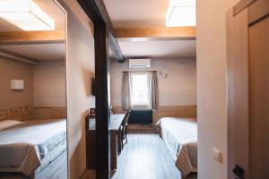 a small room with two beds and a window at Pieno Piano in Rivne