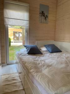 a large bed in a room with a window at Seaside Harmony in Pogorzelica