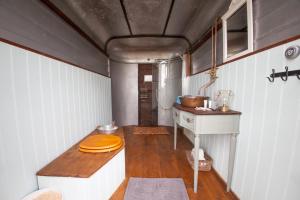 a kitchen with a table with a wooden floor at Quex Livery Glamping in Birchington