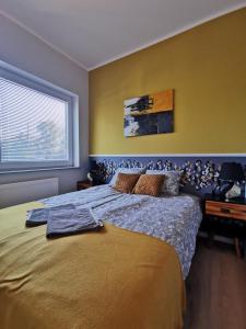 a bedroom with a large bed and a window at Chcę tu zostać Apartamenty Gdynia in Gdynia