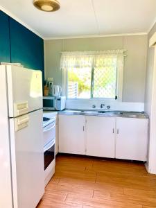 uma cozinha com um frigorífico branco e uma janela em Cottage 55 - Topspot Cottages em Jurien Bay