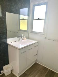 uma casa de banho branca com um lavatório e uma janela em Cottage 55 - Topspot Cottages em Jurien Bay